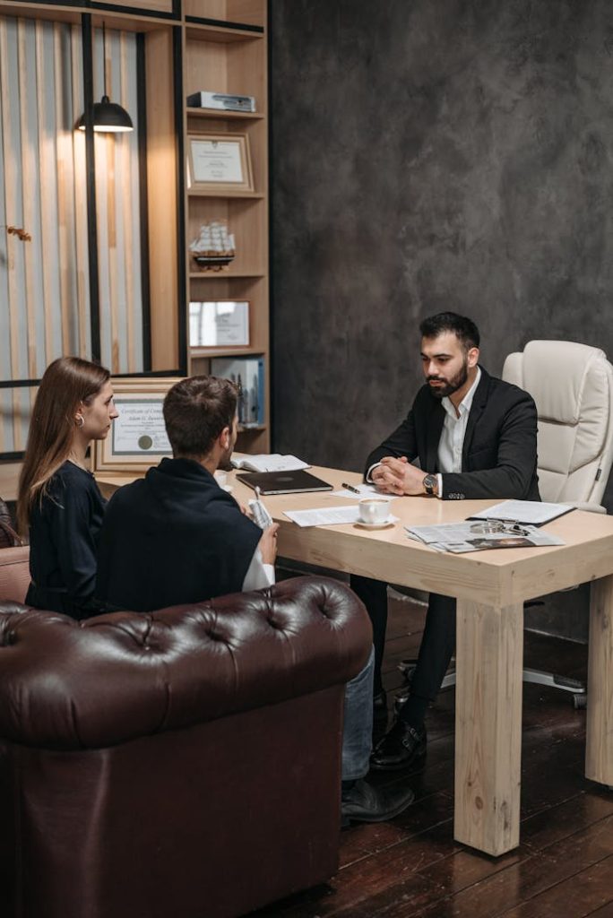 Mastering the First Impression: Your intriguing post title goes here A professional business meeting with three people discussing documents in an office setting.